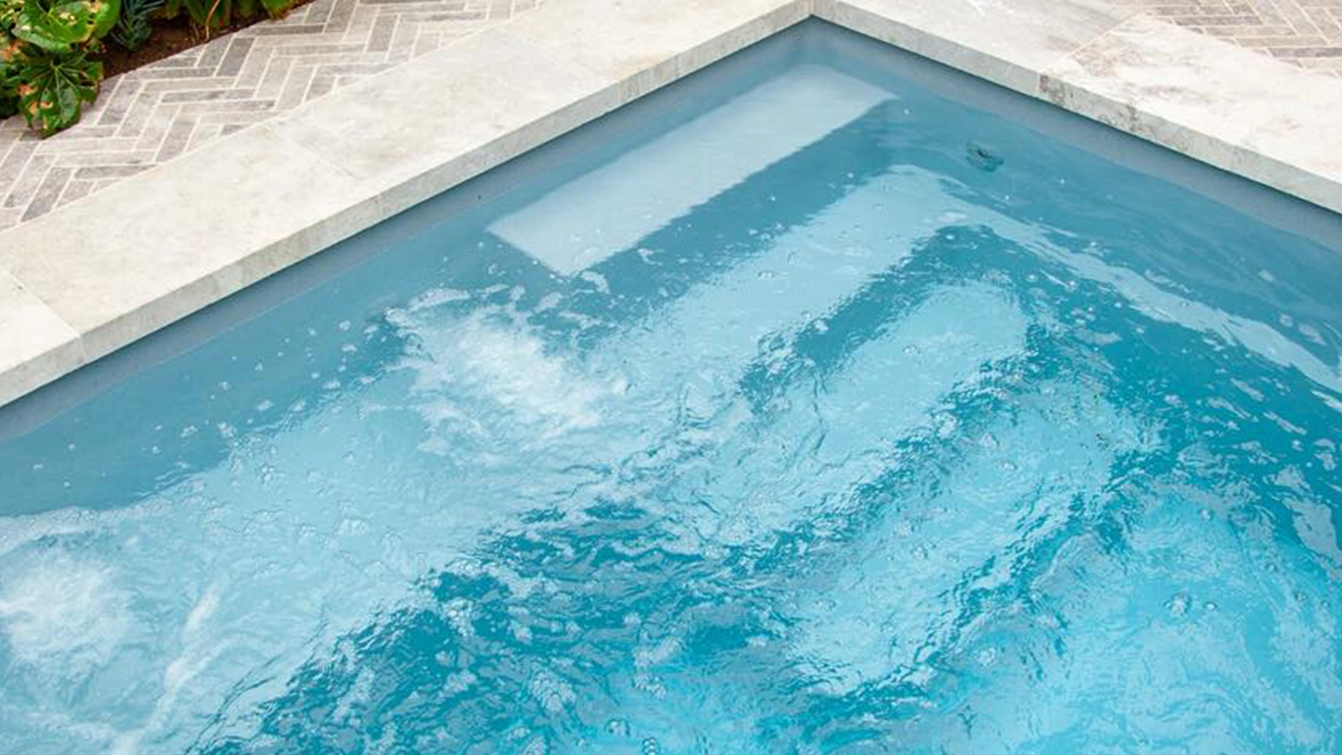 The stunning fibreglass swimming pool – The Journey – in beautiful light grey Mist colour, located in a Melbourne Bayside backyard with entry steps, bench seats, and a full-length swimming corridor.