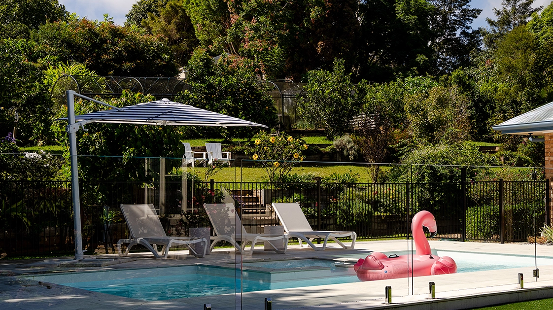 IMG NP AU The Muse Spa 7.62 Pearl 04 The Muse with Spa 7.60m in Pearl with floaty and umbrella against the tree background, installed in Sunshine Coast, QLD. Picture: Nexus Pools Sunshine Coast North.